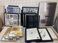 Image showing the entire lot of 18 picture frames and one family plaque, arranged on a shelf with various sizes and orientations.