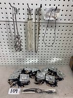 Full view of 5 necklaces hanging on hooks and multiple hair tie bracelets arranged below along with a pair of earrings.