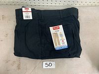 Full view of the folded black Wrangler pants with labels showing size 36x32 and brand.