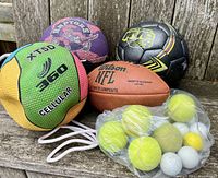 Photo showing a group of sports balls: a green and yellow XT5D 360 basketball, a Toronto Raptors mini basketball, a black and yellow tetherball, a Wilson NFL football, and a bag of golf and tennis balls.
