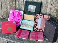 Assorted gift boxes arranged on a wooden surface showing various colors, designs, and sizes including branded and homemade boxes.