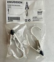 Package of two white Ikea Enudden hooks for hanging over closet rails. Packaging label showing product name and designer.