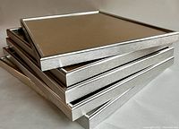 Stack of five brushed-metal picture frames showing the metallic finish and edges.