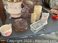 Overview photo of the six items: two covered glass dishes (one pink depression glass with metal base and one clear with lid), porcelain pink floral pitcher, two battery operated candles, small floral cup, and a small spoon.