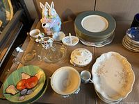 Overview of all plates and serving pieces including dinner plates, appetizer plates, ceramic figurines, glass dishes.