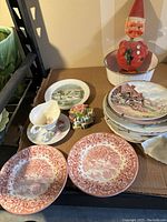 Vintage plate collection and decorative items, including red Santa Claus figure