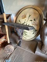 Wooden mallet leaning against a small wooden shelf and vintage round floral picture