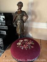 Side view photo showing statue and footstool arrangement.