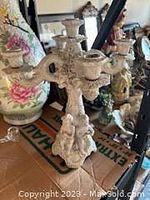 Porcelain candelabra with ornate sculptural details and three candle holders