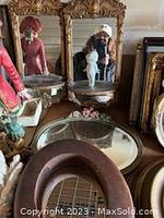 Two smaller decorative vintage mirrors, one round with floral accent and one rectangular with detailed frame, shown surrounded by other decorative items.
