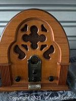 Front view of the vintage wooden cathedral style radio showing carved grille and wooden casing.