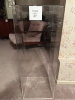 Full frontal view of clear acrylic display stand showing overall shape and transparency.