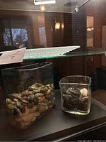 Photo of two Mexican blown glass containers filled with smooth river stones, one large and one smaller