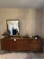 Front view of full dresser with mirror and items on top