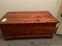 Front view of closed cedar chest showing exterior cedar wood grain and brass corner hardware