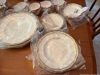 Overview of all wrapped plates, saucers and cups laid out on table