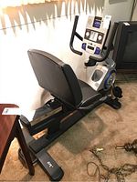 Side view of recumbent bike showing padded seat, backrest and frame