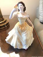 Front and right angle view showing detailed facial features, gown, and butterfly on hand.