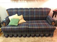 Front view of plaid sofa bed with pillows