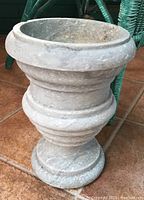 Side view of the stone planter showcasing its rounded urn shape and substantial thickness.
