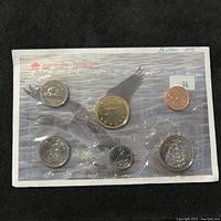 Photo of sealed 1995 Royal Canadian Mint coin set showing six coins including small cent, nickel, dime, quarter, half-dollar, and one-dollar gold coin.