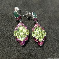 Front view of the earrings showing the arrangement of green emerald, pink garnet, and light green peridot gemstones in sterling silver.