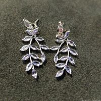 Front view of the earrings showing the leaf-like arrangement of marquise-cut light purple tanzanite stones set in sterling silver.
