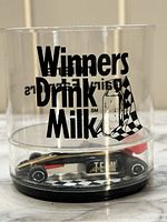 Photo of clear cup showing 'Winners Drink Milk' text and milk bottle graphic with checkered flag.