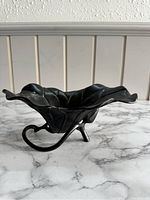 Side view of the bronze flower-shaped bowl showing petal detail and stem base