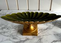 Front angle view showing the scalloped green interior and gold exterior of the retro trinket dish on a footed base.