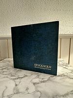 Front view of the hardcover book showing the dark blue textured cover with the title embossed in gold lettering.