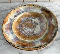 Top view of the stoneware ceramic plate showing the multicolor glaze pattern and finish.