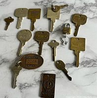 Top down photo of all keys and hotel key fob laid out on a marble surface.