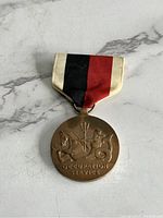 Front side of the Occupation Service Medal showing lion, horse, and trident design with ribbon.