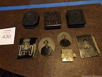 Three closed embossed cases and five loose photographic plates arranged on table