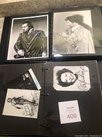 Two-page spread in binder showing four signed black-and-white portraits of performers in costume and formal attire.