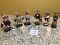 All six figurines standing in a row on a granite surface showing various Halloween costumes and animal types.