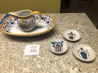 Oval ceramic platter and matching pitcher on countertop, with three small crest plates adjacent.