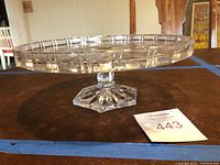 Side angle showing the height, pedestal, and edge design of the clear cut glass cake plate.