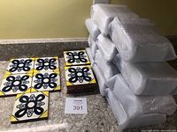 Multiple stacks of hand painted terracotta tiles showing the blue floral pattern with yellow corners and the tiles' terracotta thickness and texture.