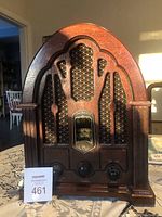 Full front view of vintage General Electric AM/FM radio housed in a wood case with decorative carved details and speaker grille.