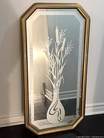 Full view of the octagonal vintage Art Deco mirror with etched floral design and gold frame leaning against a wall.