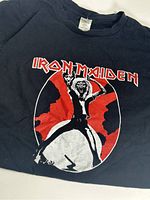 Front of black Iron Maiden t-shirt with red and white graphic and text