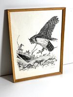 Framed vintage black and white art print displayed against a white wall, showing the entire artwork featuring an owl swooping onto a branch.
