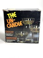 Front view of the original boxed set showing 'The Un-Candle Floating Candle Set by Corning' with an image of three different sizes of glass floating candle holders.