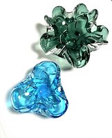 Both ashtrays on a white surface showing color and shape contrast.