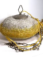 Close-up image of the textured glass shade and metal hanging top with chain.