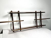 Front view of the vintage wooden wall shelf showing the two horizontal shelves and four vertical turned spindle supports.