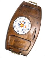 Full view of vintage wooden serving tray showing overall shape, brass handles, and carved sections.