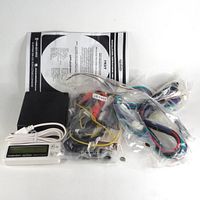 Full kit contents showing FRST interface, wiring harnesses in plastic bag, LCD screen, and instruction manual.